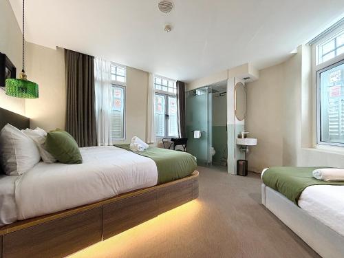 a large bedroom with two beds and a bathroom at A Hotel Chinatown in Singapore
