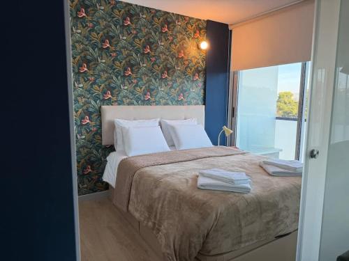 a bedroom with a large bed with a floral wall at Na Outra Margem - Douro River Views - Free Parking in Vila Nova de Gaia