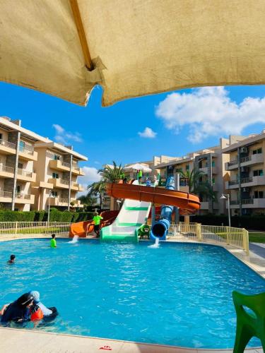 a pool at a resort with people in the water at مارينا دلتا Alpha star in ‘Izbat Abū Sulayman