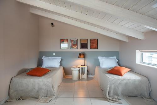 two beds with orange pillows in a room at Gela in Livadeia