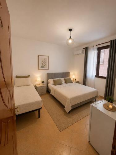 a bedroom with two beds and a table with lamps at Vacation house villa roni in Durrës