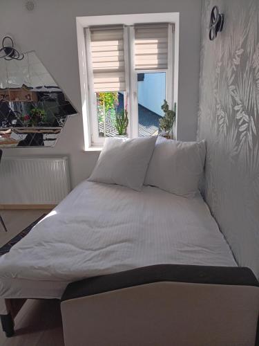 a large bed in a room with a window at Kamienica Senator in Skierniewice