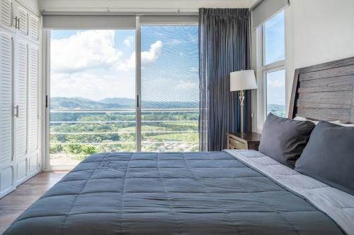 a bedroom with a large bed with a large window at Casa La Cima in Playa Hermosa