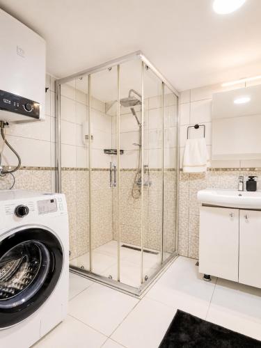 a shower in a bathroom with a washing machine at MaxiHomes Hadrian in Antalya