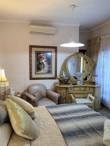 a living room with a bed and a mirror at Ronique's Guest House in Rustenburg