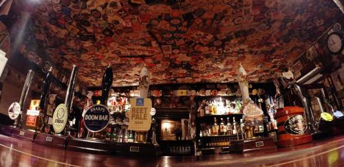 a bar with a bunch of bottles of alcohol at The Crown Inn in Rodmarton