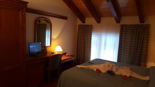 een slaapkamer met een bed, een bureau en een computer bij Hotel Castello in Montjovet