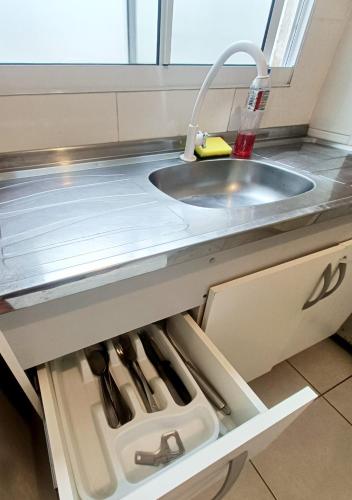 a kitchen with a sink and a drawer with utensils at Acomodações Azaleias by Rental in Palhoça
