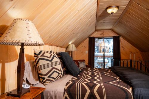 a bedroom with a bed with a lamp and a window at Riverview Cabin at O-Bar-O in Durango