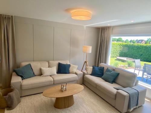 a living room with a couch and a table at Ferienhaus Lykkehus Dümmer See in Hüde