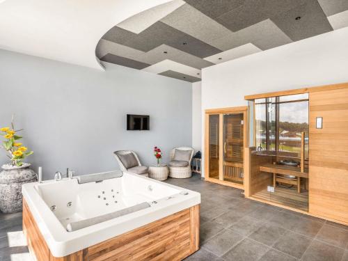 a large bathroom with a large white tub at Movenpick Resort and Spa Fruske Terme in Vrdnik