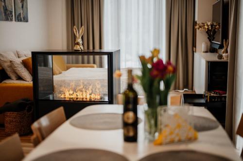 a living room with a table with a television and flowers at Apartmány Esprit in Dolný Kubín