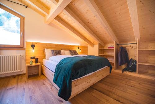 a bedroom with a bed in a wooden house at Chalet Brento in Lundo