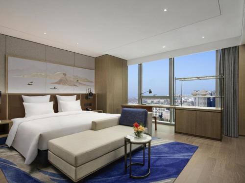 a hotel room with a bed and a couch at Pullman Huai'an in Huai'an