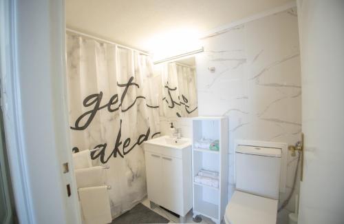 a white bathroom with a sink and a toilet at Blue Horizon Seafront Apartment in Agioi Theodoroi
