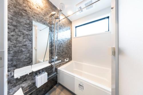 a bathroom with a tub and a sink and a mirror at 2F, 3F - Vacation STAY 20122v in Sumiyoshi