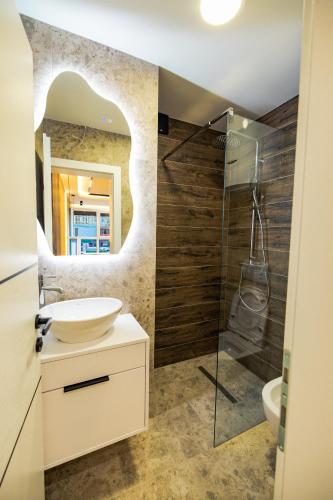 a bathroom with a sink and a glass shower at AMD LUX apartman in Bijeljina