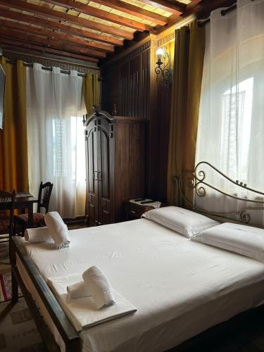 ein Schlafzimmer mit einem Bett, auf dem zwei Handtücher liegen in der Unterkunft Hotel Iliada in Tirana