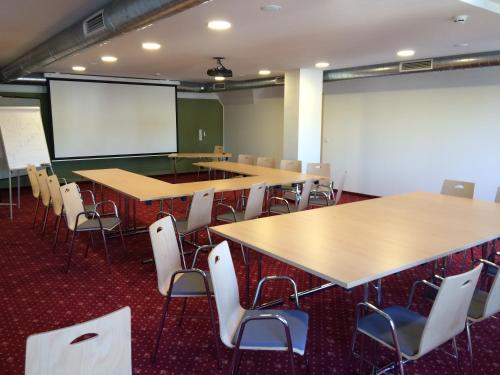 a classroom with tables and chairs and a whiteboard at Kutscherwirt in Vorau