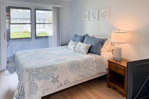 a bedroom with a bed and a tv and a window at Unit 117 for Poolside Fun in Wells