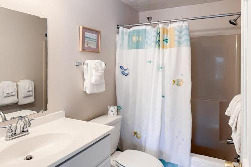 a bathroom with a toilet and a shower curtain at Unit 117 for Poolside Fun in Wells