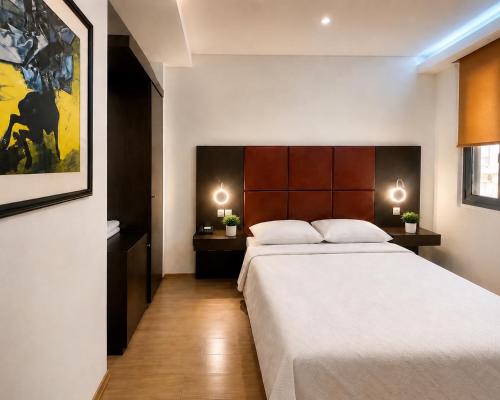 a bedroom with a large bed and two night stands at INOH Athens Hotel in Athens