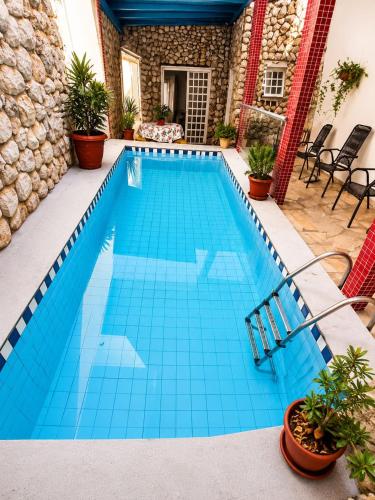 a swimming pool with blue tile in a house at Hostel Goiabeiras com Piscina Próximo à Arena Pantanal in Cuiabá
