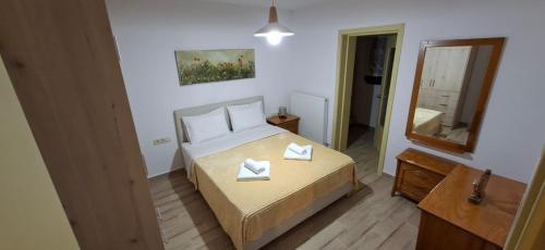 a small bedroom with a bed and a mirror at Family House in Platamonas
