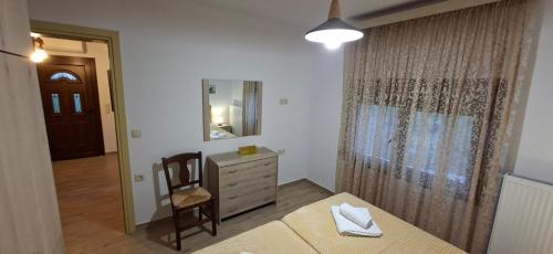 a bedroom with a bed and a dresser and a mirror at Family House in Platamonas