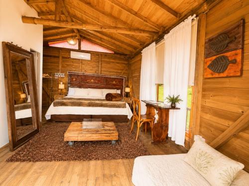 a bedroom with a bed and a table in a room at Hotel Casa Madero in Envigado