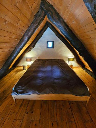 a bed in the middle of a wooden attic at Fienile in Avegno