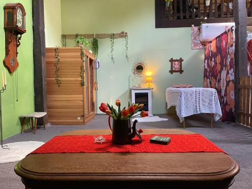 a room with a table with a vase of flowers on it at Tijd-Loos in Geeste