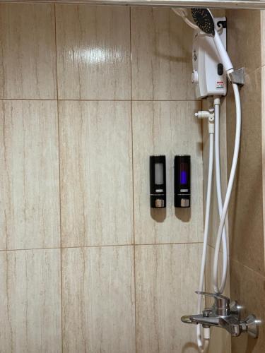 a shower in a bathroom with two soap dispensers at Corner Studio in Ermita Manila near US Embassy and SLMEC in Manila