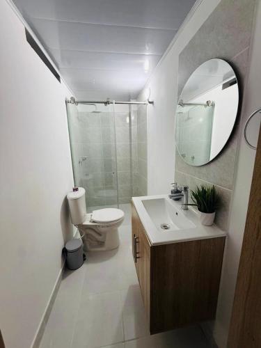 a bathroom with a toilet and a sink and a mirror at Casa Amarilla SOL Apartamento Remodelado in Piedecuesta