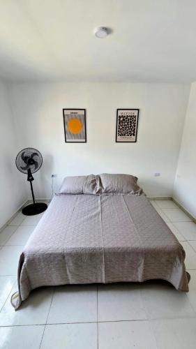 a bedroom with a large bed in a white room at Casa Amarilla SOL Apartamento Remodelado in Piedecuesta