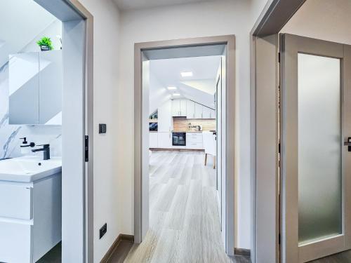 a bathroom with a door leading into a kitchen at Aparthotel Svitavy in Svitavy
