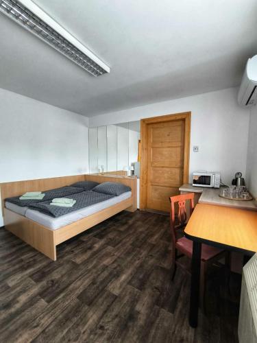 a bedroom with a bed and a desk and a table at Sokolovna in Bohumín