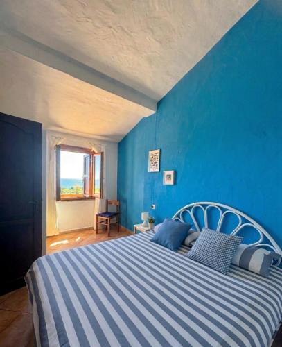 a blue bedroom with a large bed with a blue wall at Appartamenti Cala d'Ambra in San Teodoro