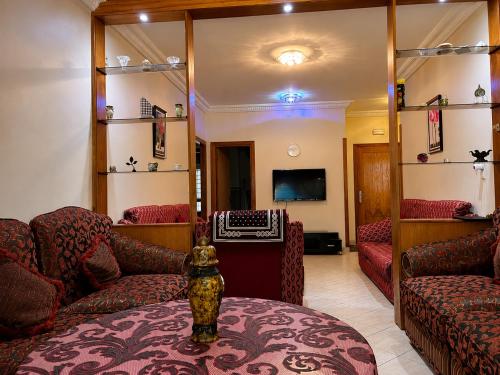 a living room with red couches and a mirror at Spacious Family Apartment - Air Conditioning, Pool & Garden Views in Martil