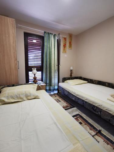two beds in a room with a window at Tri Cveta in Popadić