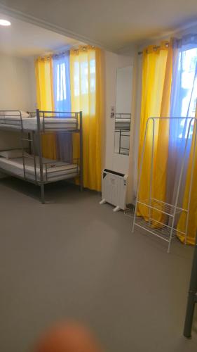 a room with two bunk beds and yellow curtains at ALBERGUE de Caldas de Reis URRACA in Caldas de Reis