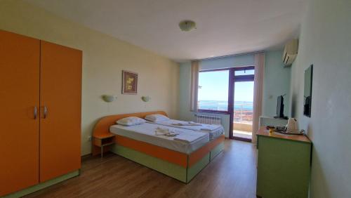 a bedroom with a bed and a large window at Guest House Byki in Sveti Vlas