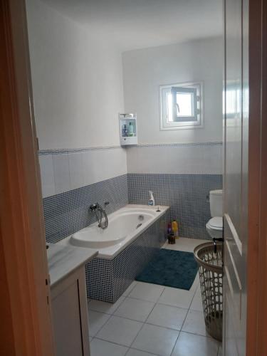 a bathroom with a tub and a sink and a toilet at Maison aux Jarres in Midoun