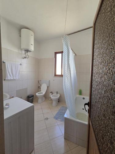 a bathroom with a tub and a toilet and a sink at Bujari Guesthouse in Berat