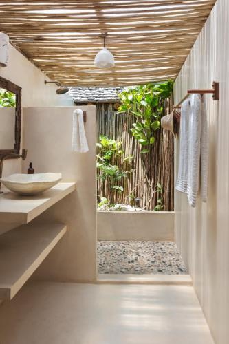 a bathroom with a shower and a sink at Casa do Amor Caraíva in Caraíva