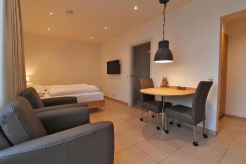 a hotel room with a bed and a table and chairs at Hof van Salland Hellendoorn in Hellendoorn