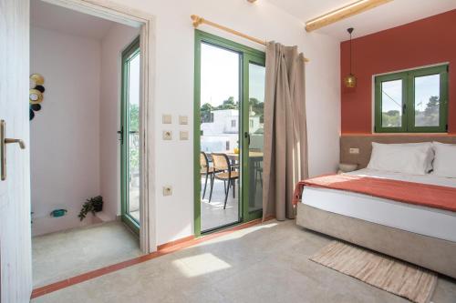 a bedroom with a bed and a balcony at Aegora Residence in Kalithies