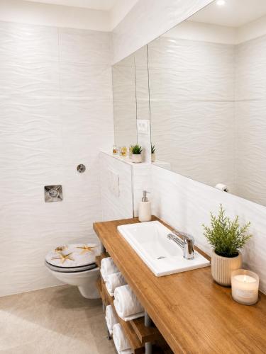 a bathroom with a sink and a toilet and a mirror at Center Vibes Lux in Rijeka