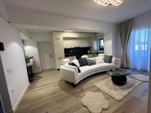 a living room with a white couch and a table at Luxury Vibes in Şelimbăr