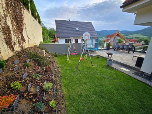 a backyard with a playground and a play area at Dom pri jazere Nitrianske Rudno in Kostolná Ves